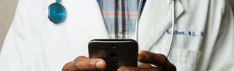 doctor with stethoscope with phone in hands